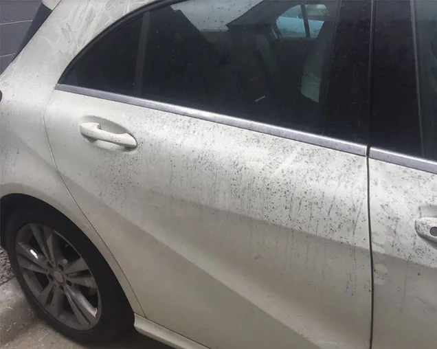 White Mercedes A-Class showing heavy fallout contamination on the rear quarter