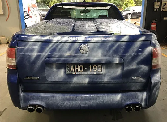 Rear of the blue Holden ute with fallout contamination